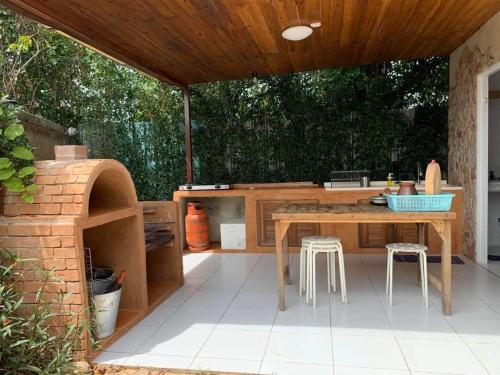 an outdoor kitchen with a table and stools at ForestPoolvilla in Na Jomtien