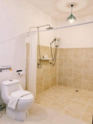 a bathroom with a white toilet and a shower at ForestPoolvilla in Na Jomtien