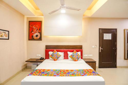 um quarto com uma cama e um tecto em FabHotel Pine Tree em Noida