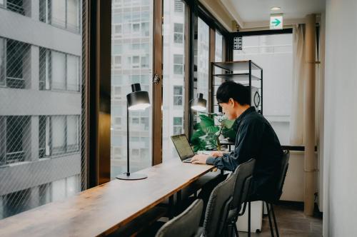 a man sitting at a desk with a laptop at unito light SHIMBASHI in Tokyo