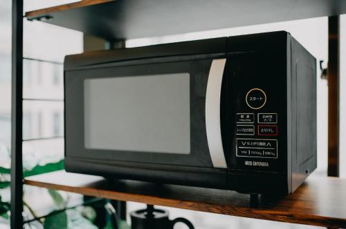 a microwave oven sitting on top of a shelf at unito light SHIMBASHI in Tokyo