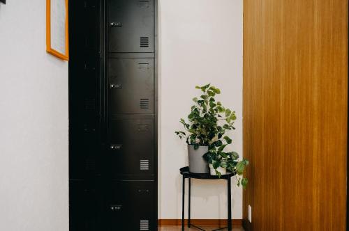 a room with two black lockers and a potted plant at unito light SHIMBASHI in Tokyo