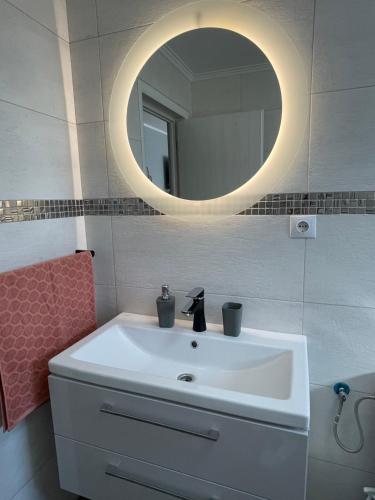 bagno con lavandino bianco e specchio di Tiberiu Ricci Apartament a Sibiu