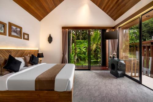 een slaapkamer met een bed en een groot raam bij Villa Three Little Birds by BaliSuperHost in Ubud