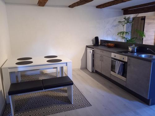 eine kleine Küche mit einem Tisch und einem Waschbecken in der Unterkunft der brennerhof in Immendingen