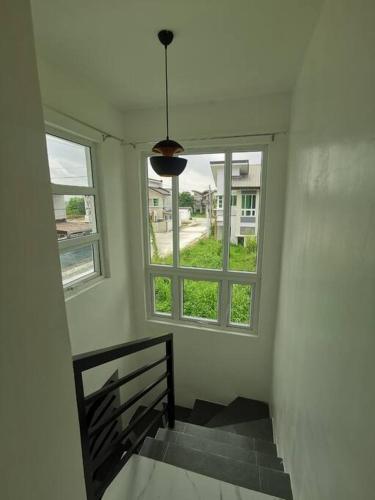 a stairway with two windows and a stair case at JRLB PLACE - Accommodation in Concepcion, Tarlac in Concepcion