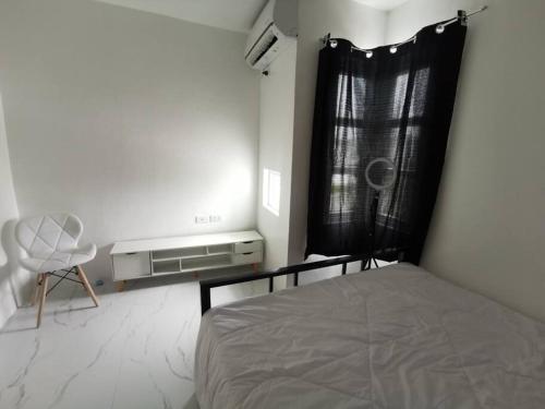 a bedroom with a bed and a chair and a window at JRLB PLACE - Accommodation in Concepcion, Tarlac in Concepcion