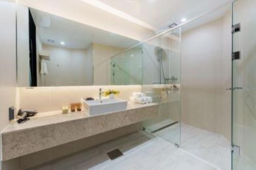 a bathroom with a sink and a glass shower at Kwangsu Hotel Haeundae in Busan