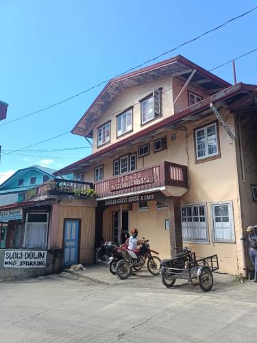 a man sitting on a motorcycle in front of a building at Sagada Guesthouse in Sagada