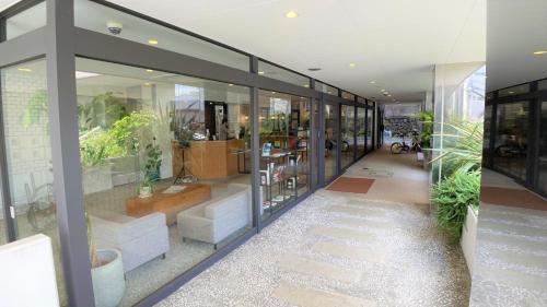 eine Lobby eines Gebäudes mit Fenstern und Pflanzen in der Unterkunft Hotel Gee Haive in Mishima