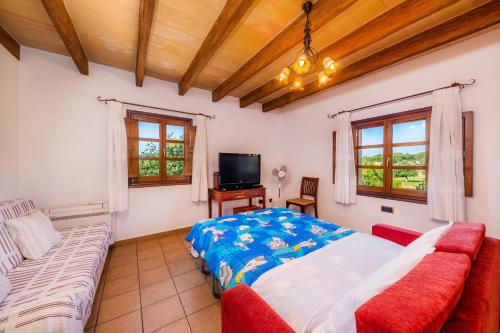 una camera da letto con un letto e un divano di Villa Cas Cuni a Felanitx
