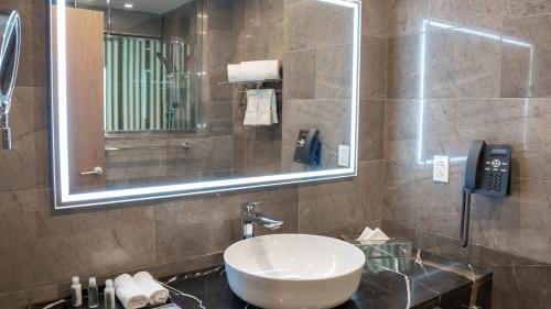 a bathroom with a sink and a mirror and a phone at Holiday Inn Santo Domingo by IHG in Santo Domingo