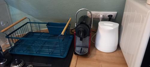a dish drying rack with utensils in a kitchen at Le studi'ault de la plage in Ault