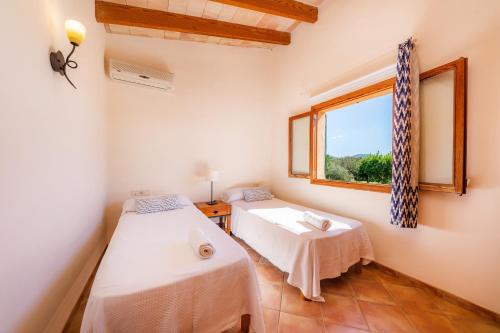 a room with two beds and a window at Sa Torreta in Algaida