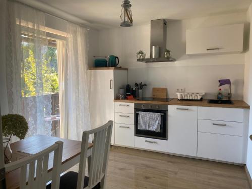 a kitchen with white cabinets and a table and a window at Vogelnest in Linden