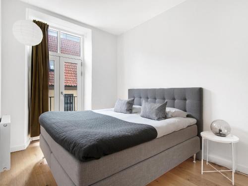 ein Schlafzimmer mit einem großen Bett und einem Fenster in der Unterkunft Sanders Leaves - Pleasant Four-Bedroom Apartment In Downtown Copenhagen in Kopenhagen
