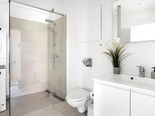 a white bathroom with a toilet and a shower at Sanders Leaves - Pleasant Four-Bedroom Apartment In Downtown Copenhagen in Copenhagen