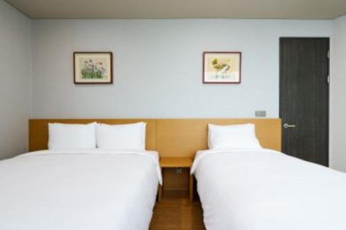 two beds sitting next to each other in a room at Kwangsu Hotel Haeundae in Busan