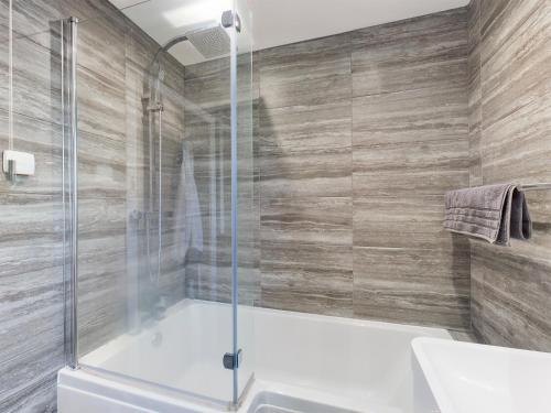 a bathroom with a shower with a tub and a sink at Contemporary 2 bedroom eco home with a twist in Marton