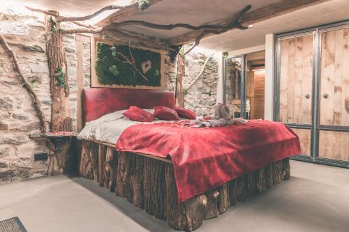 1 dormitorio con 1 cama grande en una pared de piedra en Romantic Getaway - Sauna and Jacuzzi - El Clandestino, en Stoumont