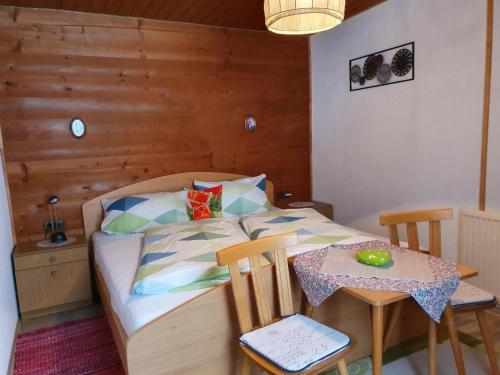 Schlafzimmer mit einem Bett und einem Tisch mit Stühlen in der Unterkunft Bauernhof Neu-Endfelden, Günter Widauer in Söll