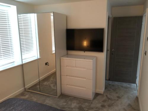 a room with a tv and a cabinet with a mirror at Contemporary 2 bedroom eco home with a twist in Marton