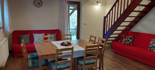 a dining room with a table and a red couch at Chalupa Maršíkov 120 in Velké Losiny