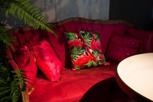 a red couch with three pillows on it at Anna King Hotel in Chiayi City