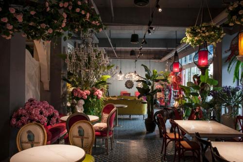 een restaurant gevuld met tafels, stoelen en bloemen bij Anna King Hotel in Chiayi City
