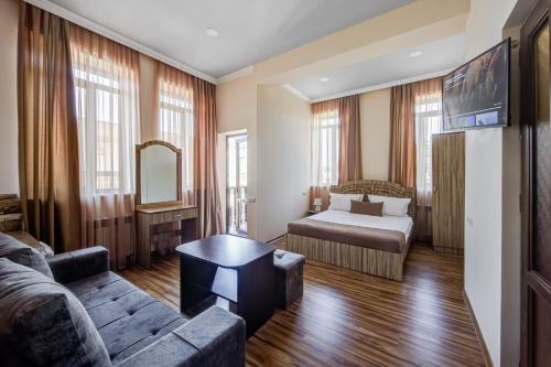 H Resort Hotel Vagharshapat Armenia في Vagharshapat: غرفة معيشة مع أريكة وسرير