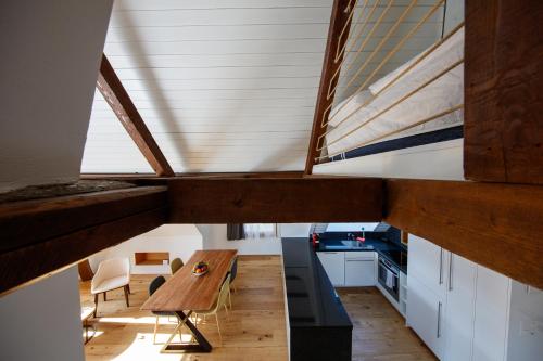 a kitchen with a wooden table and a ceiling at BERG & BERG APARTMENTS - Spiez Self-Check-in in Spiez