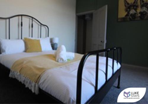 sypialnia z łóżkiem z białą pościelą i żółtymi poduszkami w obiekcie Luke Stays - Alum Waters w mieście New Brancepeth