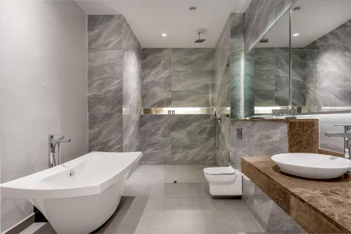 een badkamer met een bad, een wastafel en een toilet bij The Art Hotel in Lagos