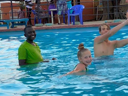 a group of boys swimming in a swimming pool at The Sparrow Hotels in Soroti