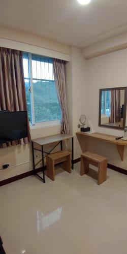 a living room with a television and a table and a mirror at 106 Homestay in Ruifang