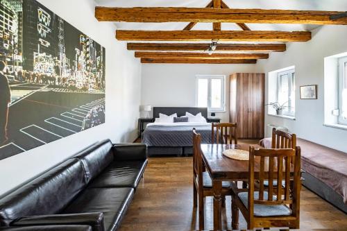 ein Wohnzimmer mit einem Sofa, einem Tisch und einem Bett in der Unterkunft Apartmány Gulliver in Mikulov