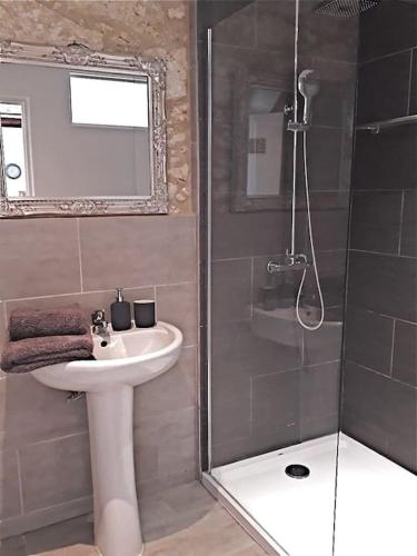 une salle de bain avec un lavabo et une douche dans l'établissement Labarthe Gites Pigeonnier, à Saint-Aubin-de-Cadelech