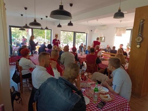 a group of people sitting at tables in a restaurant at Fruškogorski djeram in Grgeteg