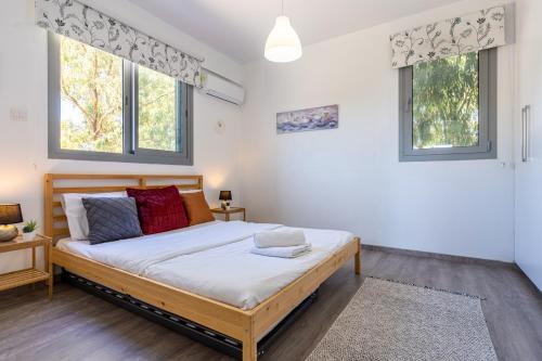 une chambre avec un lit et deux fenêtres dans l'établissement Kmeidos 1-Bedroom Apartment in Larnaca, à Larnaka