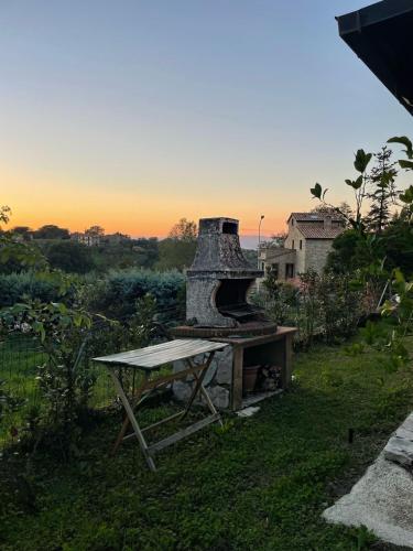 an outdoor grill with a table in the grass at CASA LORY Poggio Murella in Poggio Murella