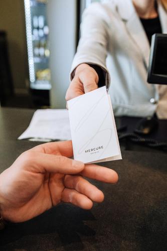 a person holding a white card in their hand at MERCURE KLAIPEDA CITY HOTEL, Meetings, Events, Restaurant & Bar - Accor Group, Pet Stay FREE in Klaipėda