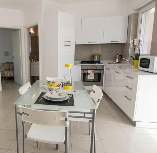 a kitchen with a table with a bowl of fruit on it at Geranio-Buganville-Viola in Arco