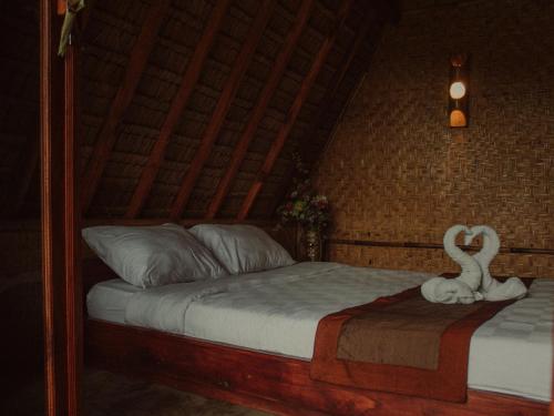 a bedroom with a bed with a swan statue on it at Da'kayu Glamping in Munduk