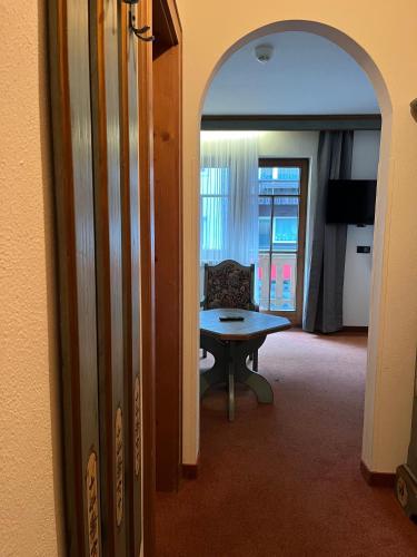 a hallway with a room with a table and a couch at Center Rooms & Apartments in Mayrhofen
