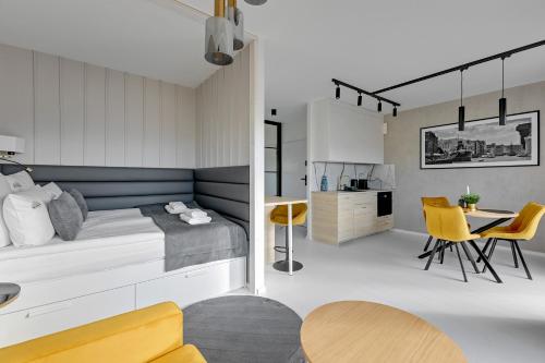 um quarto com uma cama, uma mesa e cadeiras em Downtown Apartments Nadmotławie Riverside & Gym em Gdansk