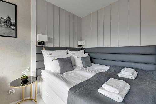 um quarto com uma cama com duas toalhas em Downtown Apartments Nadmotławie Riverside & Gym em Gdansk