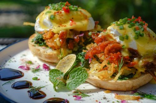 a plate with two breakfast sandwiches with eggs on it at Bali Aroma Exclusive Villas in Seminyak