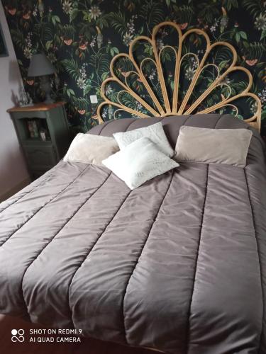 a bedroom with a bed with a gold headboard at LA PETITE MEUNIERE in Tramain