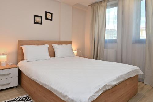 ein Schlafzimmer mit einem großen Bett und einem Fenster in der Unterkunft Durau Residence in Piatra Neamţ