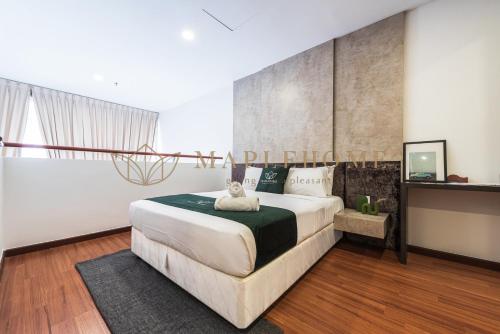 um quarto com uma cama grande com um gato deitado sobre ela em i-City Premier Suites Shah Alam em Shah Alam